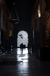 Rear view of people walking in illuminated building