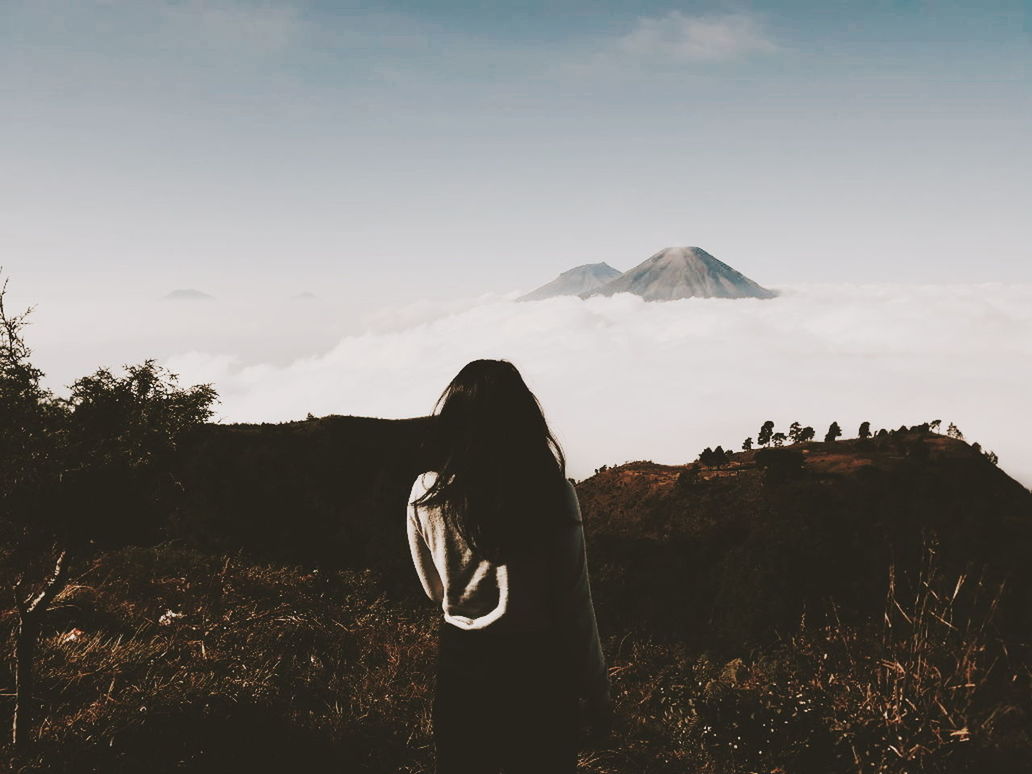 sky, mountain, land, real people, beauty in nature, lifestyles, scenics - nature, nature, landscape, field, one person, environment, rear view, plant, leisure activity, tranquil scene, tranquility, non-urban scene, volcano, outdoors, hairstyle