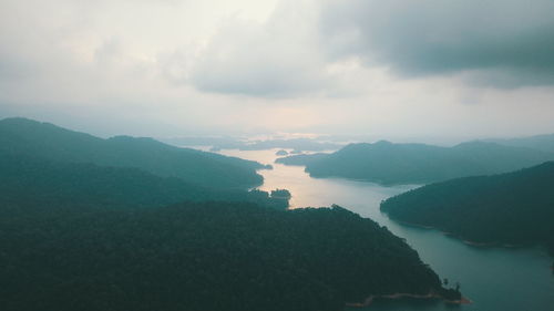 Scenic view of sea and mountains against sky