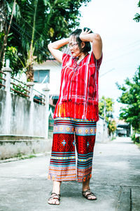 Full length of woman with red shirt standing in city