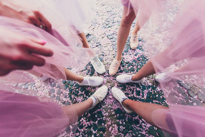 Midsection of woman standing on pink hands