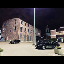 Cars on street against buildings in city at night