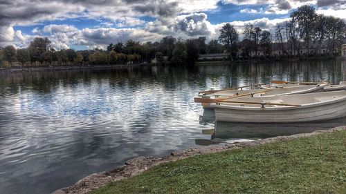 Boats moored in lake against sky