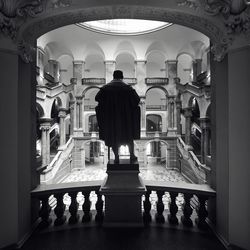 Rear view of people standing in corridor of building