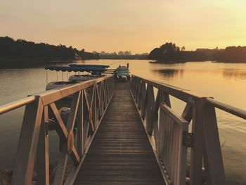 View of jetty in lake at sunset