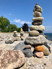 Stack of stones on shore against sky