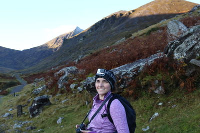 Portrait of young woman standing on mountain