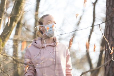 Woman wearing mask standing at park