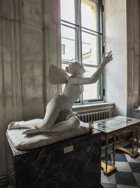 Low section of woman sitting on wooden wall