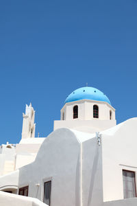 Low angle view of whitewashed church at santorini against clear sky