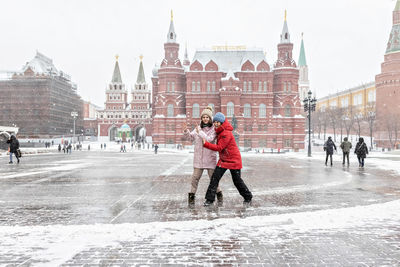 Full length of woman with umbrella against sky during winter