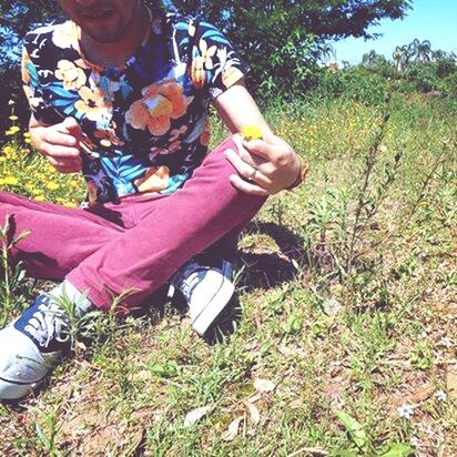 lifestyles, leisure activity, grass, casual clothing, field, holding, person, tree, sitting, childhood, day, growth, outdoors, grassy, plant, park - man made space, young adult