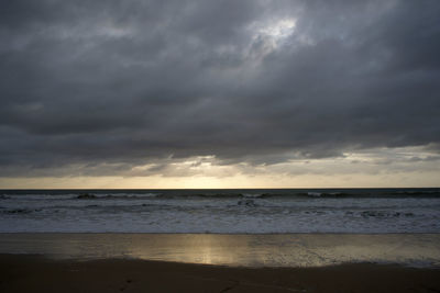 Scenic view of sea against storm clouds