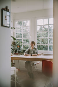 Man sitting on table by window