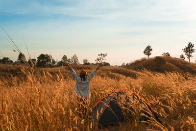 Rear view of woman on field against sky