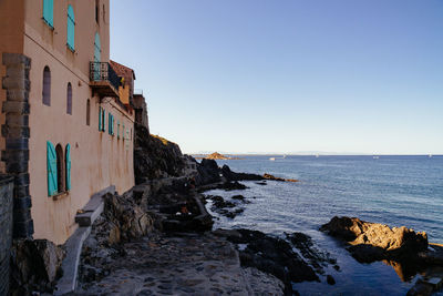 Scenic view of sea and buildings against clear sky