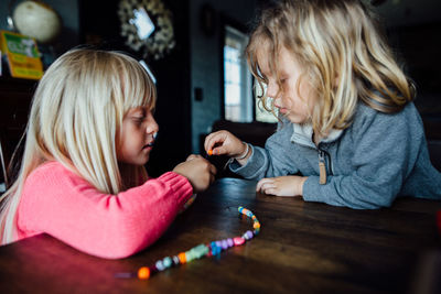 Mother and girl sitting on table