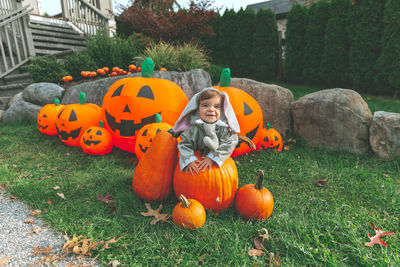 High angle view of girl and pumpkins on field