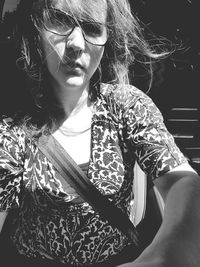 Young woman looking down while sitting outdoors