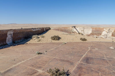 Scenic view of abandoned swimming pool at ghost town kolmanskop against blue sky, namibia