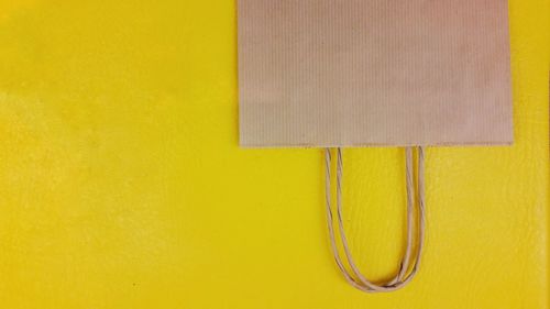 Close-up of yellow paper against wall