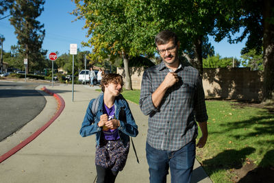 Daughter looks up at father as he walks with her to school