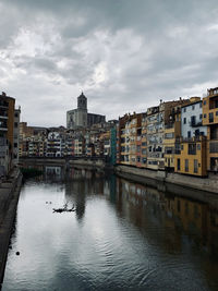 River by buildings against sky in city