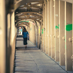 Rear view of man walking in tunnel