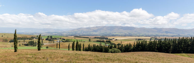 Panoramic view of field against cloudy sky