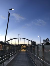 Street lights on bridge against sky