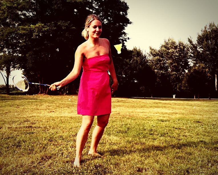 PORTRAIT OF YOUNG WOMAN STANDING ON GRASS