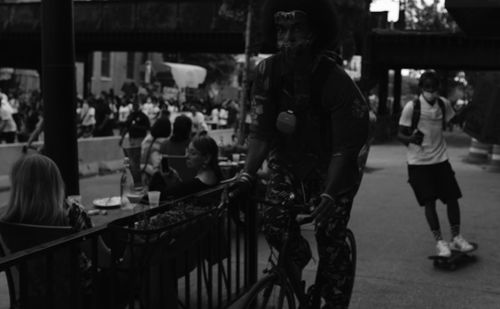 Group of people standing on street in city