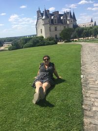 Full length of woman on field against building