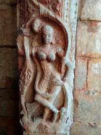 Close-up of buddha statue against wall