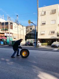 Man walking on street against buildings in city