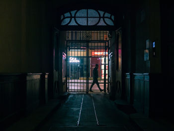 Man walking by illuminated building