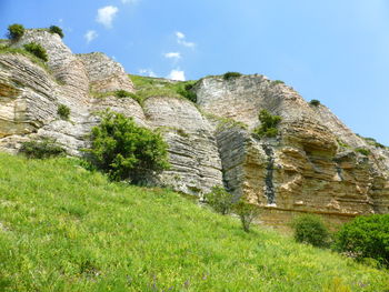 Low angle view of rock formations against sky