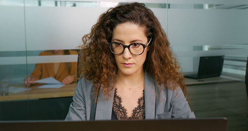 Concentrated businesswoman working online on computer at office. 