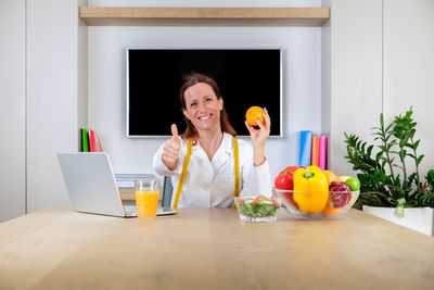 Portrait of young woman using laptop on table