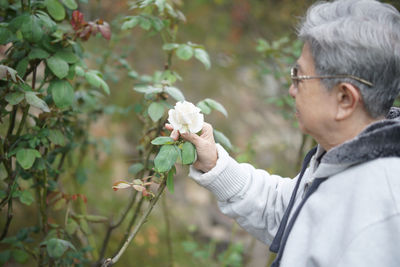 Side view of man holding flowers