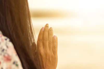 Young woman praying hands at sunset