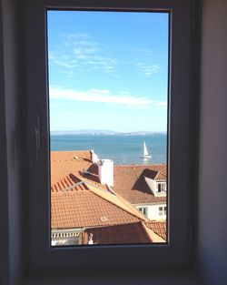 Sea against sky seen through window