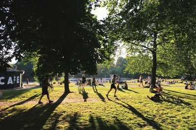 People playing soccer in park against sky