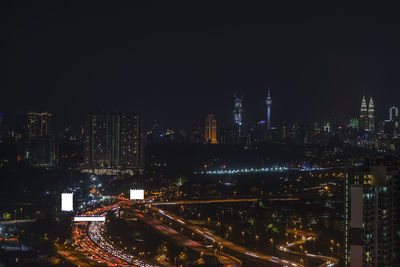 High angle view of illuminated buildings against sky at night