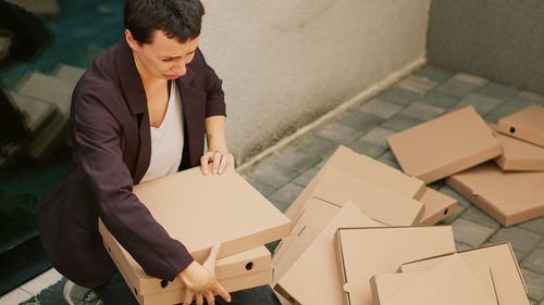 Side view of young man holding box