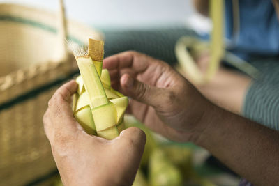 Weaving the coconut leaves making the ketupat, a traditional malay cuisine for the eid celebration.