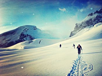 Tourists on snow covered mountain