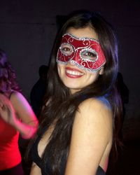 Close-up portrait of smiling young woman wearing mask