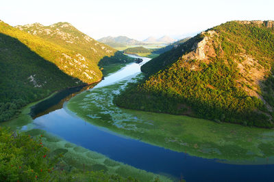 Scenic view of river amidst mountains against sky