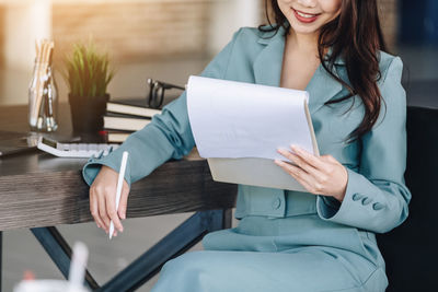 Midsection of woman using laptop